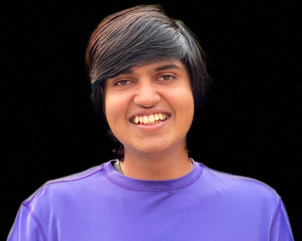 vardhan agrawal smiling in a square profile photo with black background and purple t-shirt